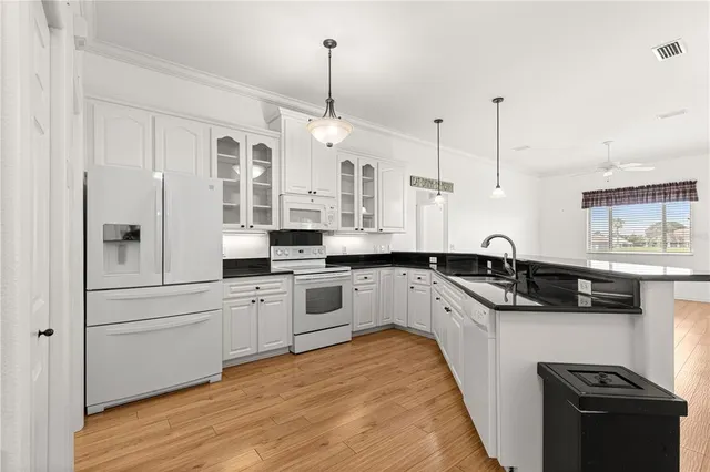 a kitchen with stainless steel appliances granite countertop a sink a stove and white cabinets