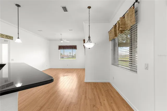 a view of a room with wooden floor and a ceiling fan