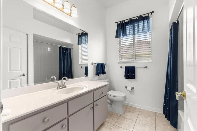 a bathroom with a double vanity sink toilet and shower