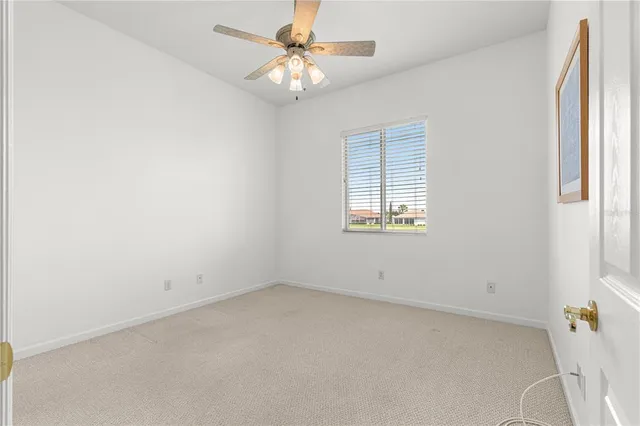an empty room with a window and a fan