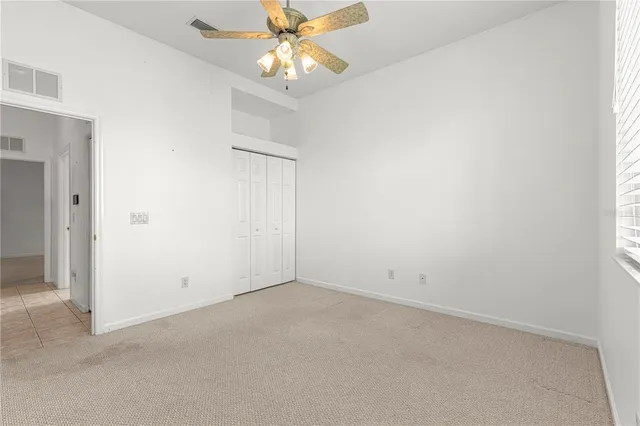 an empty room with a window and a fan