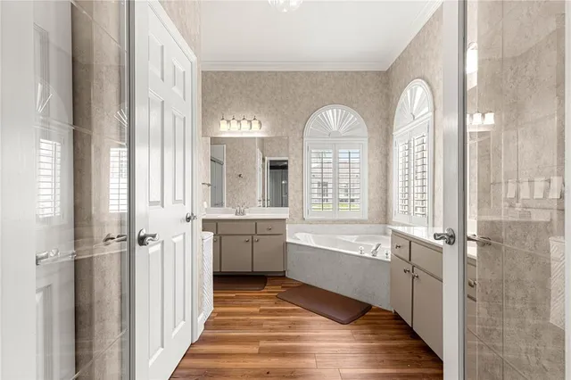 a spacious bathroom with a double vanity sink a mirror and a bathtub