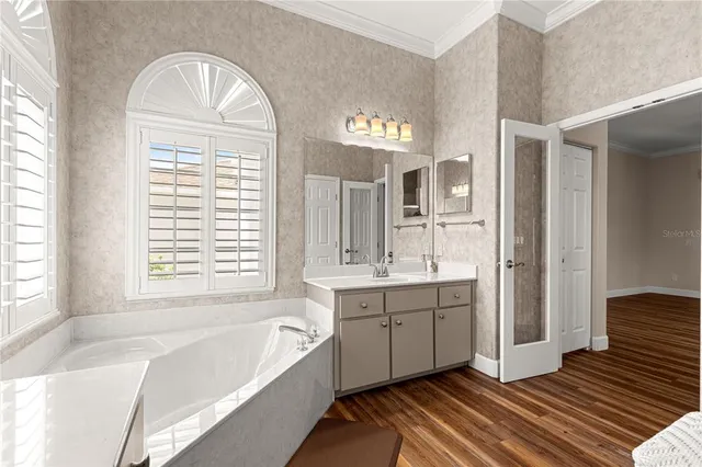 a spacious bathroom with a tub sink and mirror