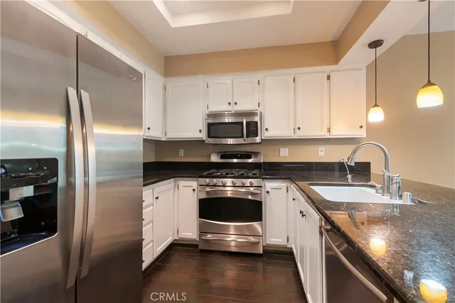 a kitchen with stainless steel appliances granite countertop a stove a refrigerator and a sink