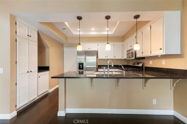 a kitchen with stainless steel appliances granite countertop a sink a stove and a refrigerator