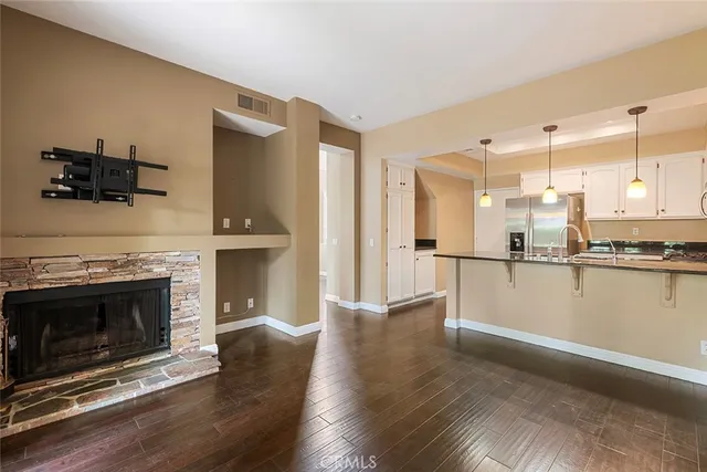 a view of a kitchen with a sink a fireplace and wooden floor
