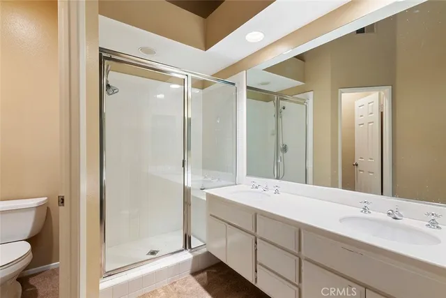 a bathroom with a double vanity sink mirror and shower
