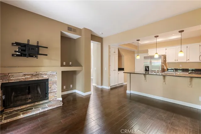 a view of a kitchen with a sink a fireplace and wooden floor