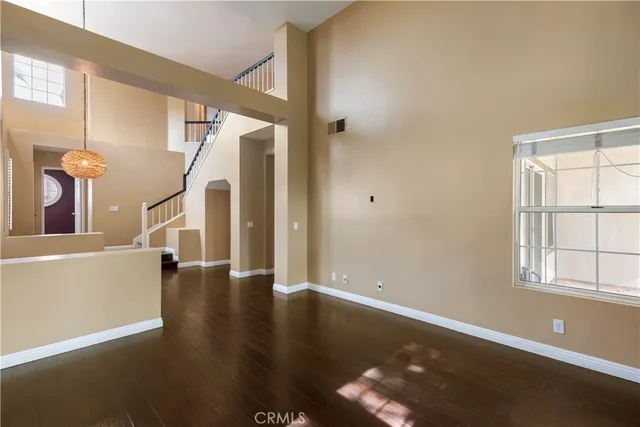 a view of a livingroom with wooden floor and stairs