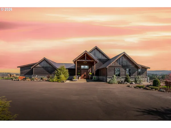 a view of a big house with a big yard and large trees