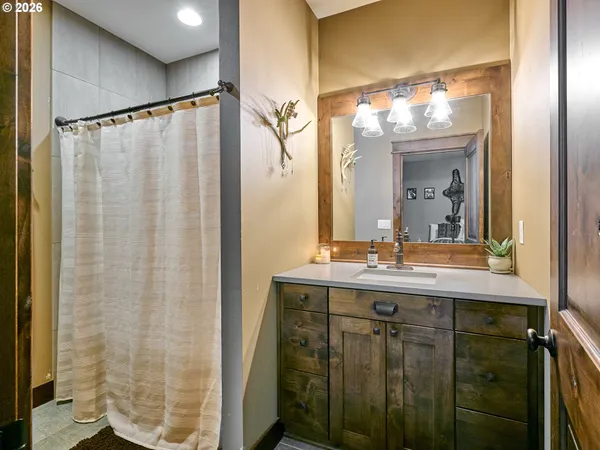 a bathroom with a granite countertop sink a mirror a vanity and a shower