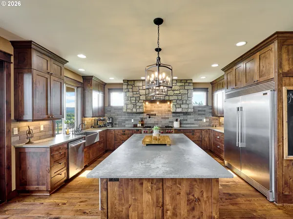 a kitchen with stainless steel appliances granite countertop a sink refrigerator and cabinets