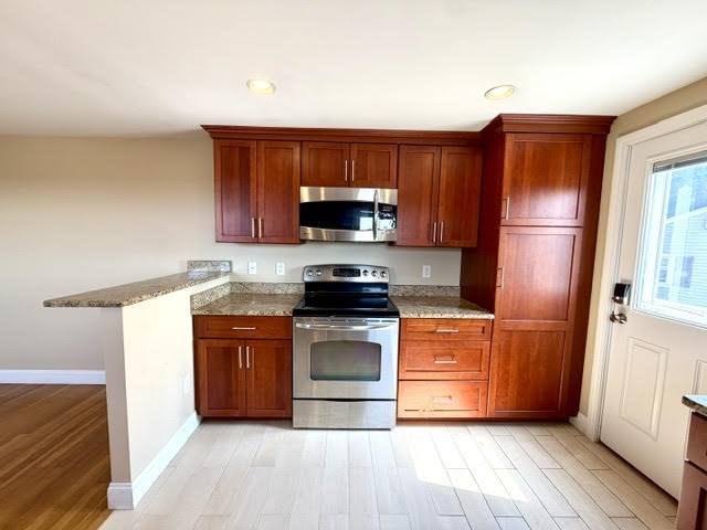 116 Upton Road Waltham, MA 02452 - Photo 5 of 22 a kitchen with granite countertop wooden floors and stainless steel appliances
