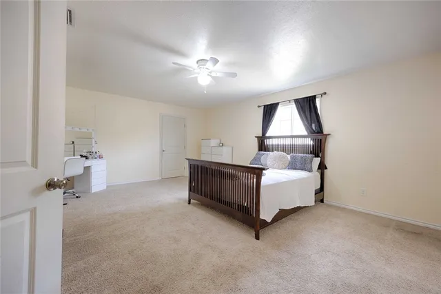 a spacious bedroom with a bed and a chandelier