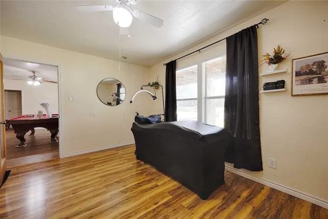 a living room with furniture and a large mirror next to a window