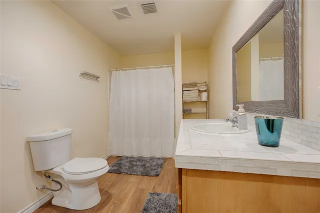 a bathroom with a granite countertop sink mirror vanity and toilet