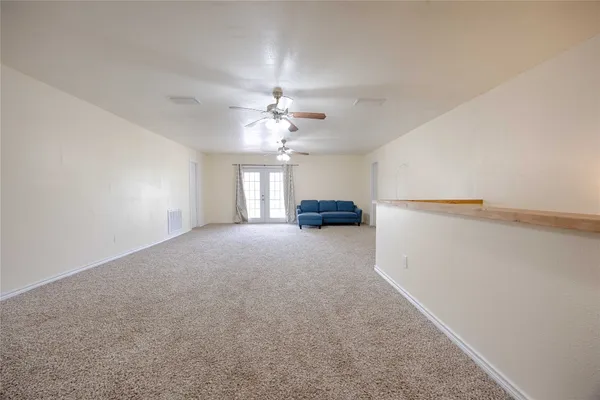 a view of empty room with a ceiling fan and window