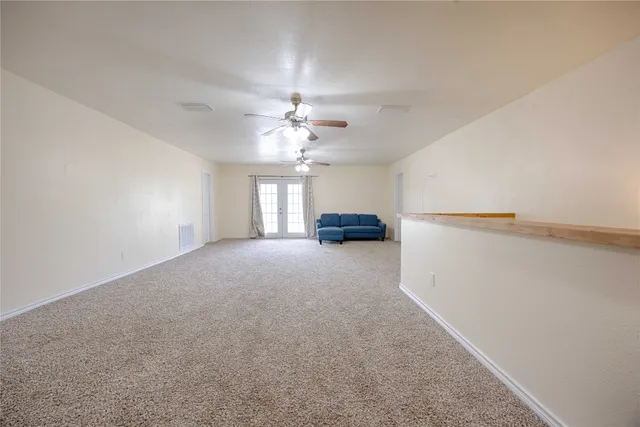 a view of empty room with a ceiling fan and window