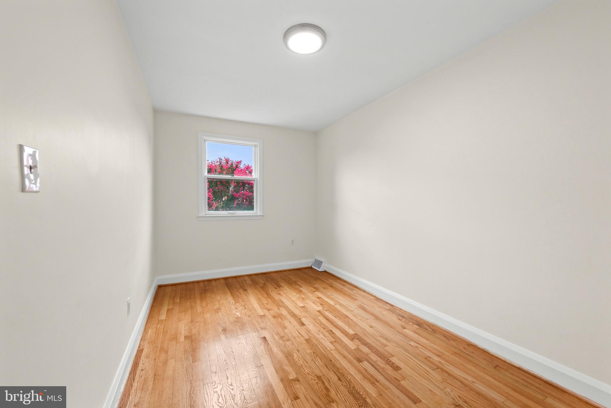 2207 Hawthorne Road Baltimore, MD 21220 - Photo 22 of 39 an empty room with wooden floor and windows
