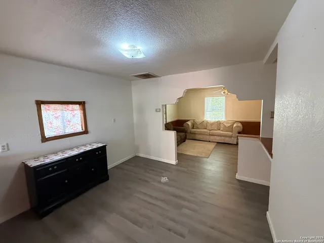 a view of a kitchen with a sink stove cabinets and empty room