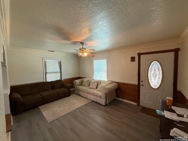 a living room with couch a mirror and a clock