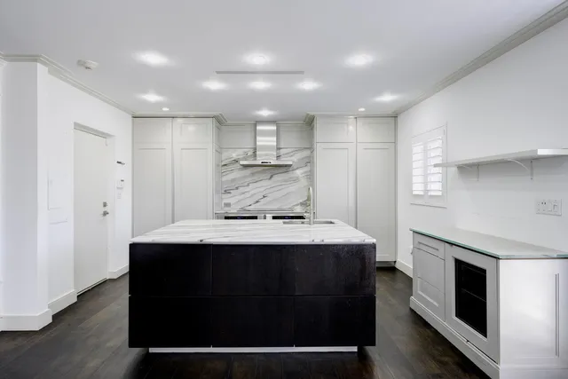 a kitchen with kitchen island a sink stainless steel appliances and cabinets