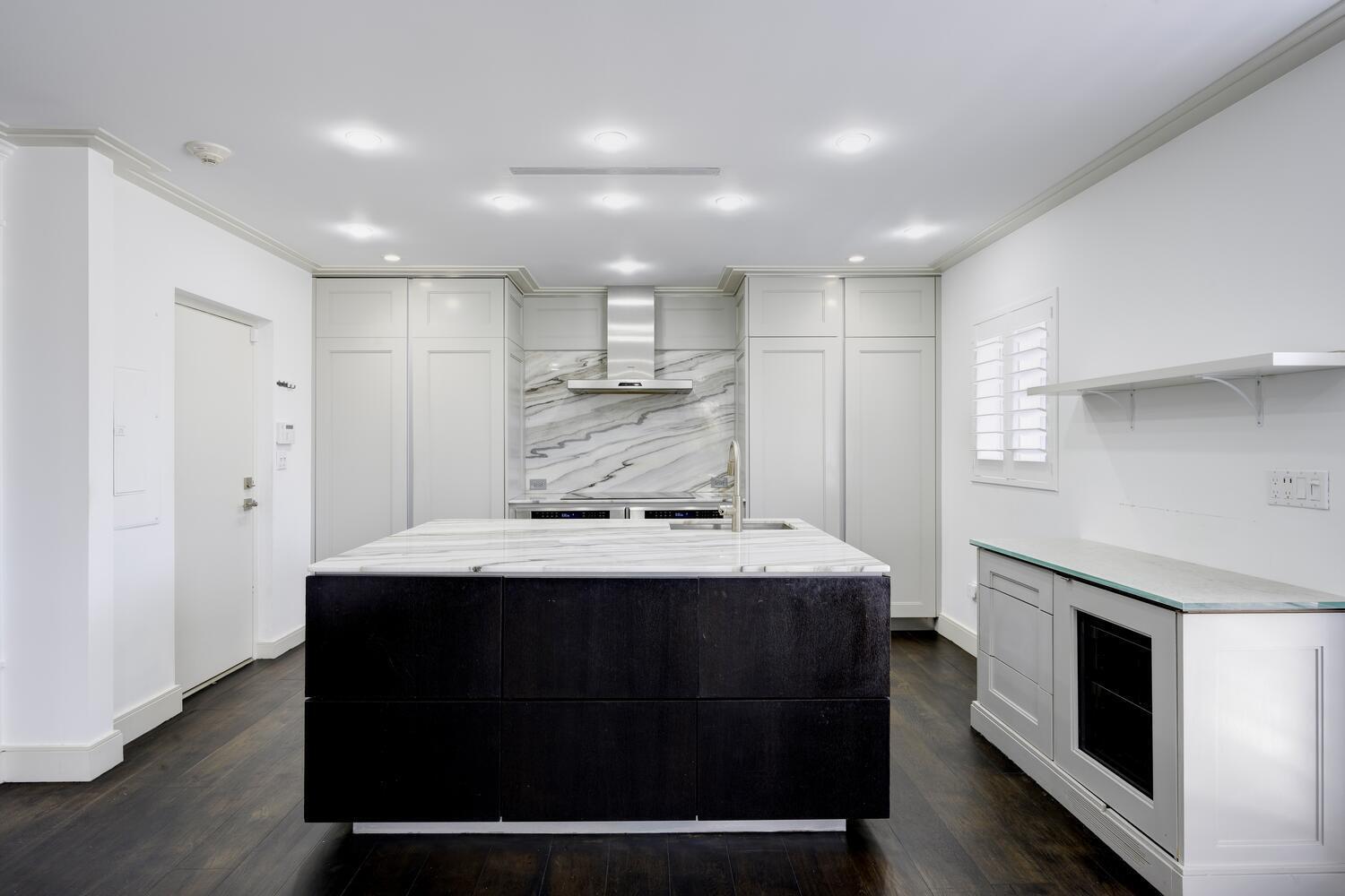 429 Australian Avenue, Unit 9 Palm Beach, FL 33480 - Photo 2 of 18 a kitchen with kitchen island a sink stainless steel appliances and cabinets