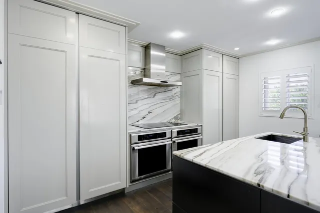 a kitchen with stainless steel appliances kitchen island a refrigerator sink and stove