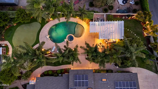 an aerial view of a house with a swimming pool outdoor seating and yard