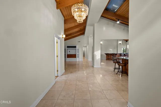 a view of a hallway with dining area and chandelier