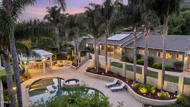 a view of a swimming pool with sitting area and furniture