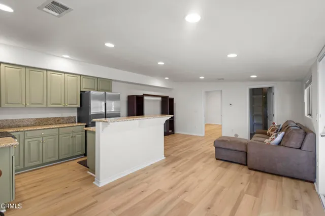 a view of a big room with wooden floor and windows