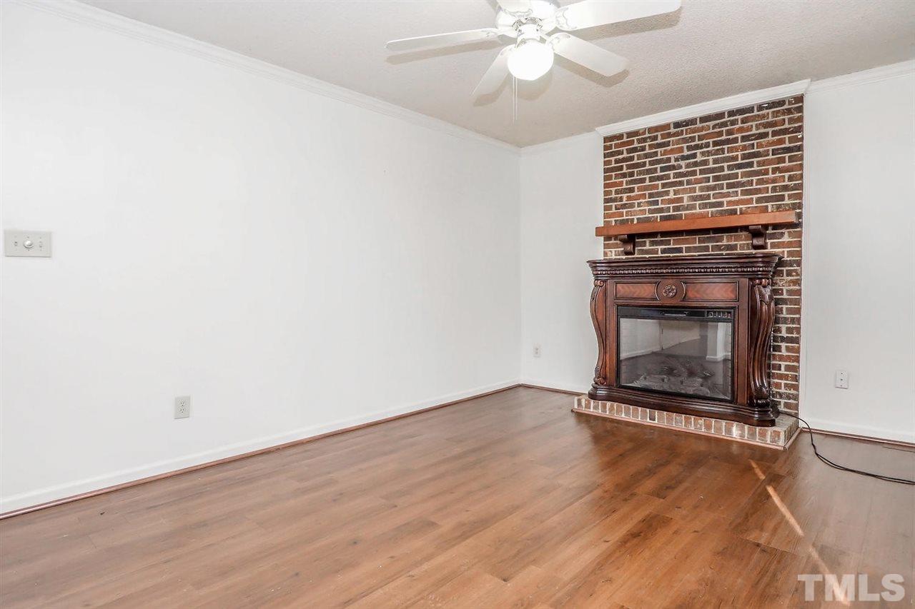 2309 Carthage Circle Raleigh, NC 27604 - Photo 13 of 23 an empty room with a fireplace and fan