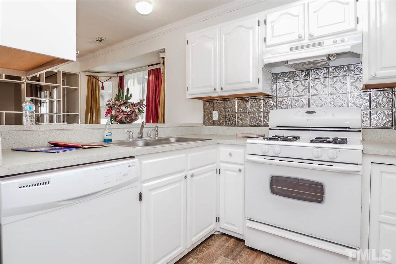 2309 Carthage Circle Raleigh, NC 27604 - Photo 7 of 23 a kitchen with white cabinets and white appliances