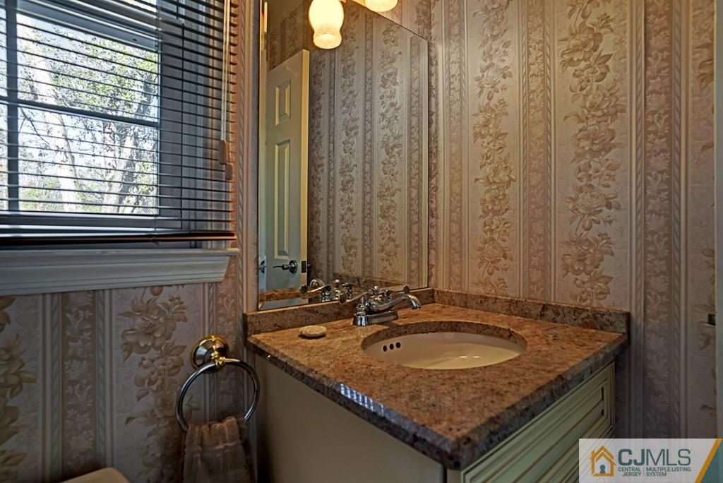 1081 Raritan Road Scotch Plains, NJ 07076 - Photo 11 of 27 a bathroom with a granite countertop sink and a mirror