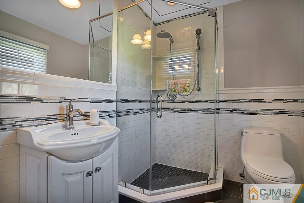 1081 Raritan Road Scotch Plains, NJ 07076 - Photo 14 of 27 a bathroom with a sink toilet and a mirror