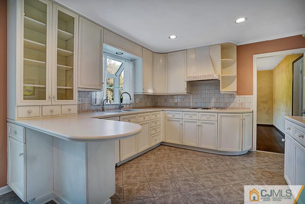 1081 Raritan Road Scotch Plains, NJ 07076 - Photo 7 of 27 a kitchen with a sink stove and cabinets