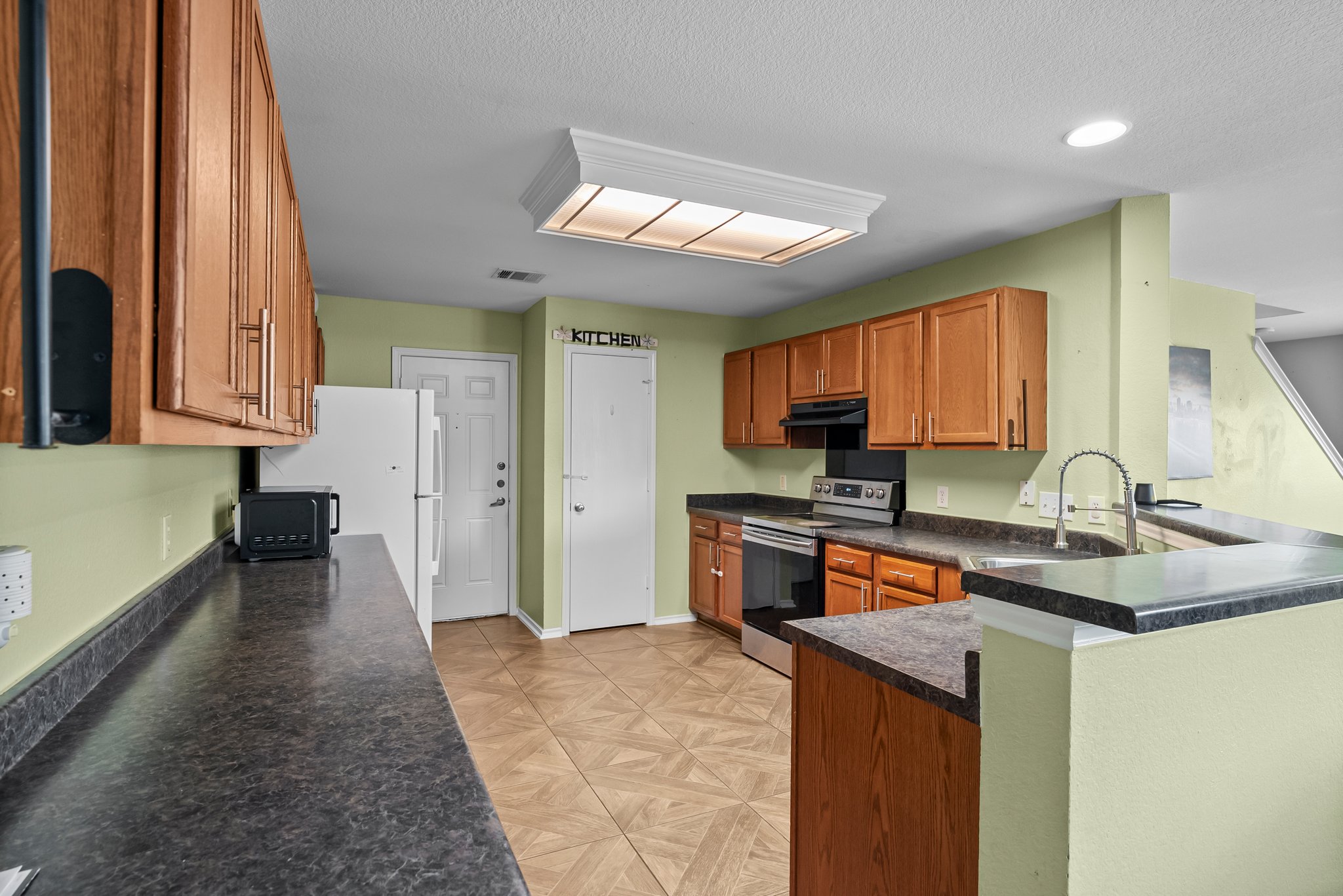 6829 Walkup Lane Austin, TX 78747 - Photo 8 of 18 A functional kitchen features wood cabinetry, durable countertops, and sleek stainless steel appliances.