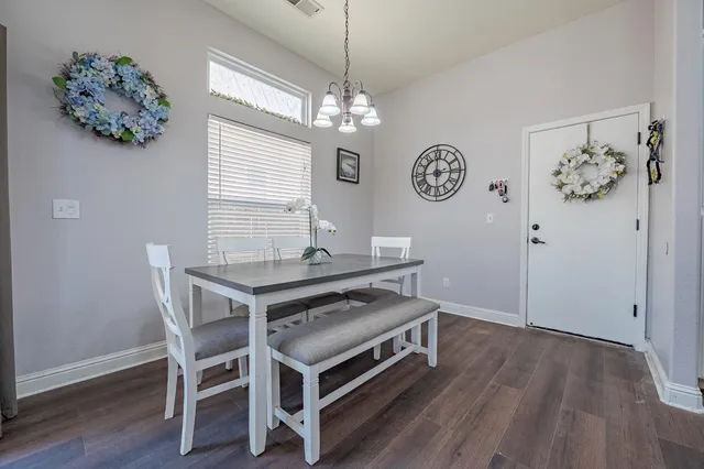 a view of a dining room with furniture wooden floor and a chandelier