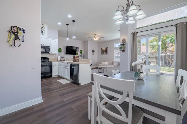 a open dining room with kitchen island stainless steel appliances furniture a chandelier and kitchen view