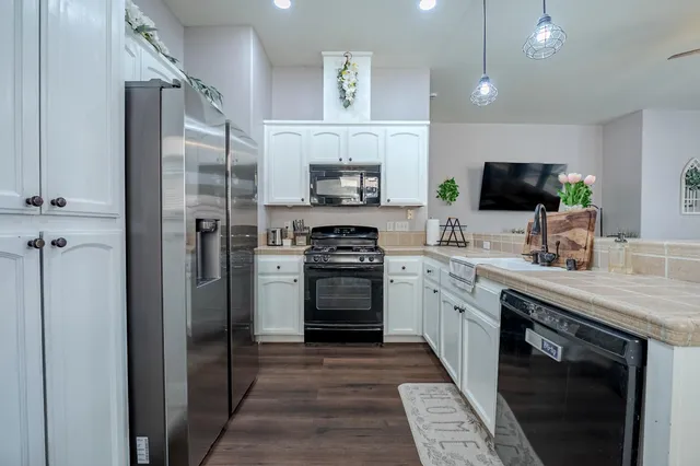 a kitchen with stainless steel appliances granite countertop a refrigerator stove and sink