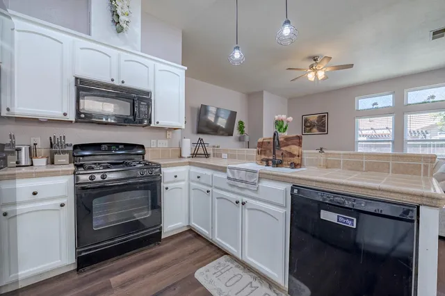 a kitchen with stainless steel appliances granite countertop a stove sink microwave and cabinets