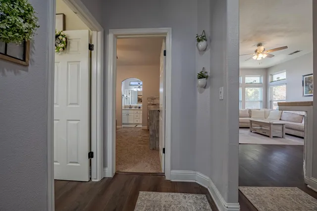 a view of a hallway with wooden floor and a living room