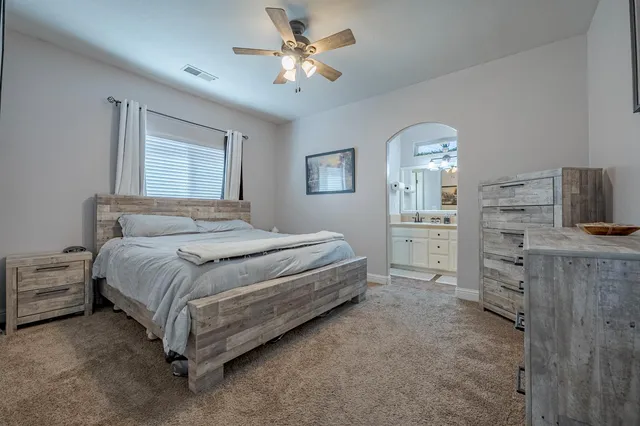 a spacious bedroom with a bed and a chandelier