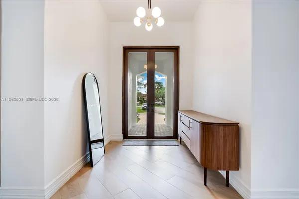 an empty room with wooden floor and mirror