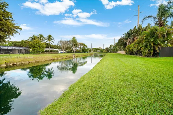 a front view of a house with a yard and potted plants