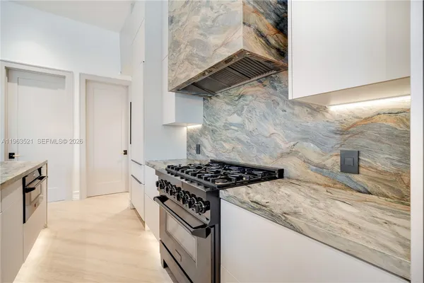 a large kitchen with a sink and a large mirror