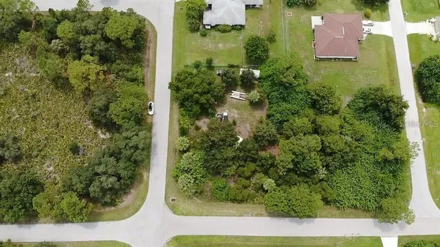 an aerial view of residential houses with outdoor space and trees