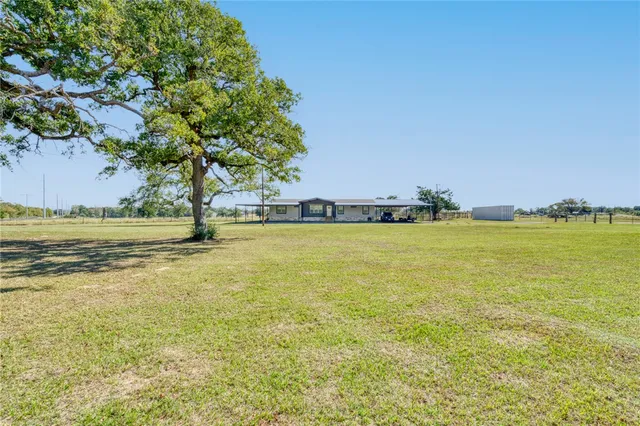 a view of a big yard with a table and chairs