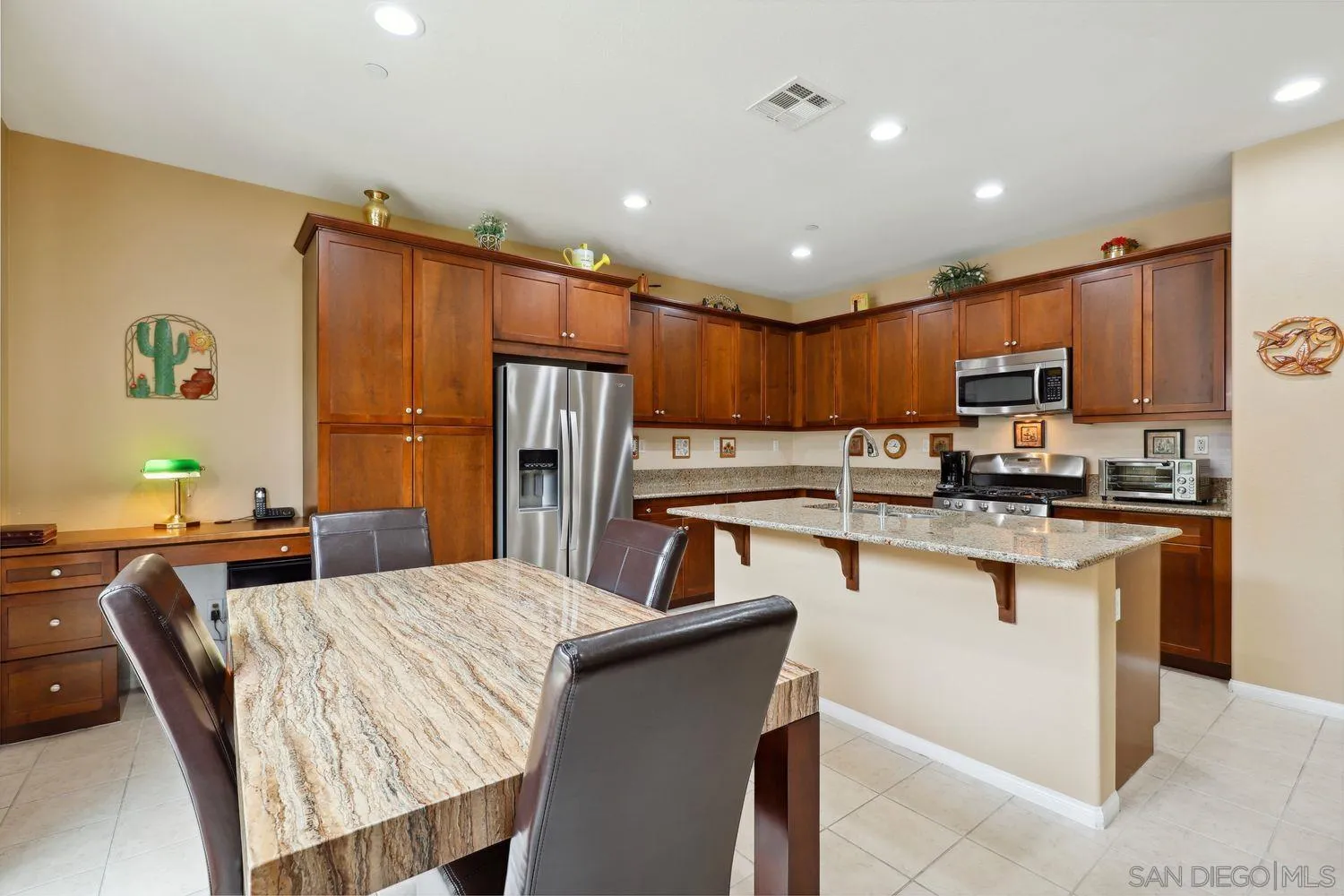 3250 Beven Drive Escondido, CA 92027 - Photo 11 of 34 a kitchen with kitchen island a refrigerator a stove a sink a dining table and chairs